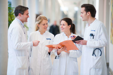 Four physicians discussing in Hallway at Heidelberg University Hospital